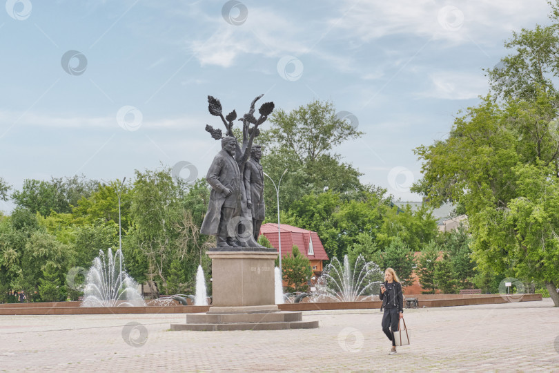 Скачать Девушка прогуливается по центру города мимо памятников Абаю и Пушкину, фонтана с дельфинами,Петропавловск,Казахстан фотосток Ozero