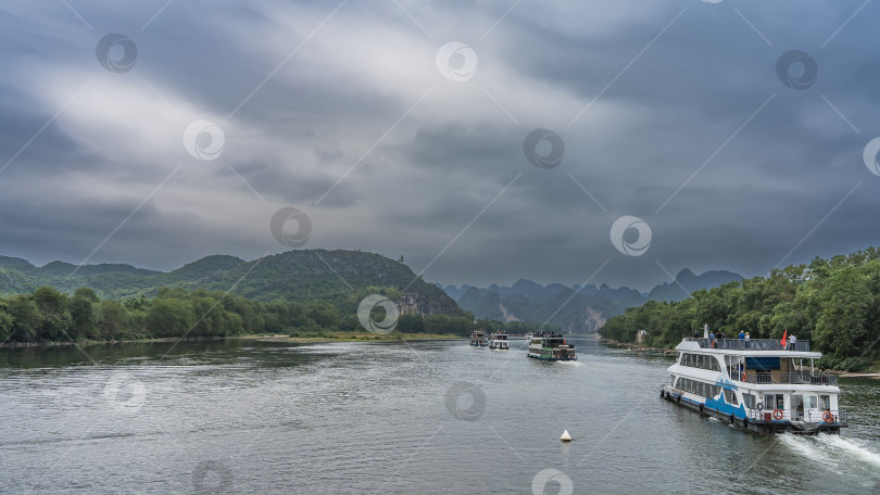 Скачать По реке в ряд проплывают туристические суда. фотосток Ozero