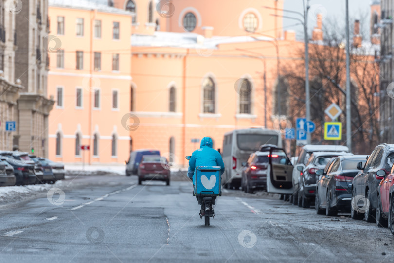 Скачать Россия, Санкт-Петербург, декабрь 2024 года: Зимой заказы по городу доставляет велокурьер фотосток Ozero