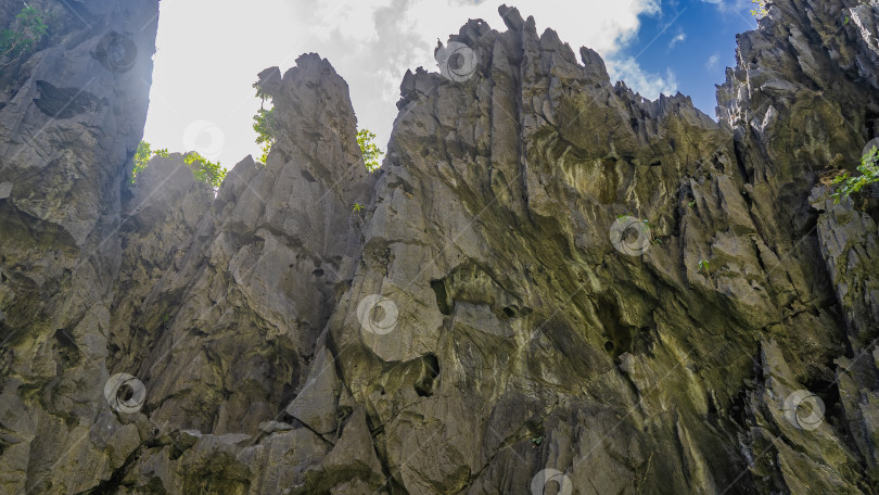 Скачать Отвесные карстовые скалы на фоне голубого неба и облаков. фотосток Ozero