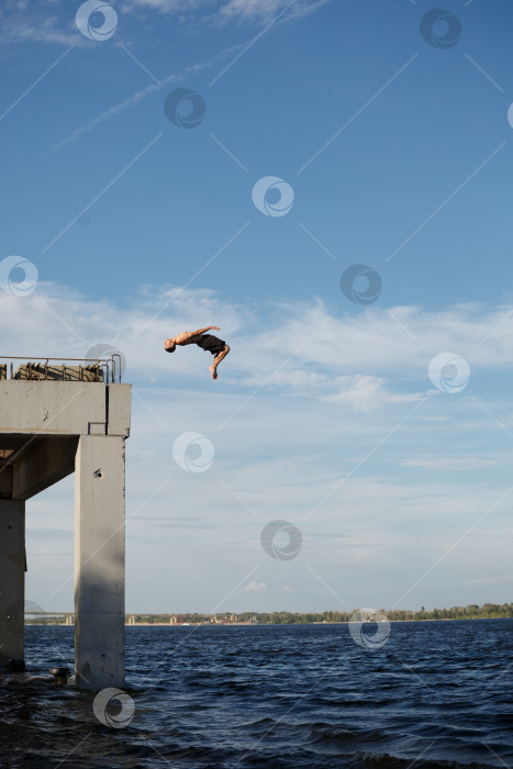 Скачать Мужчина прыгает в море с пирса фотосток Ozero