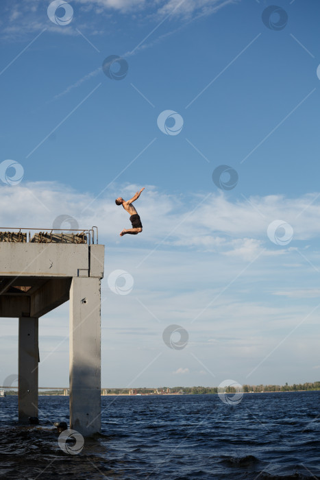 Скачать Мужчина прыгает в море с пирса фотосток Ozero