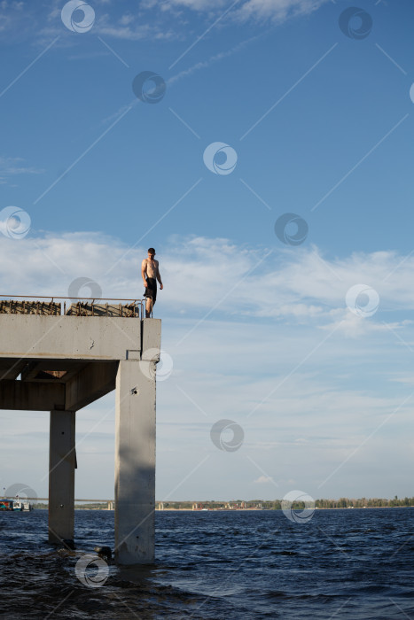 Скачать Человек стоит на морском пирсе фотосток Ozero