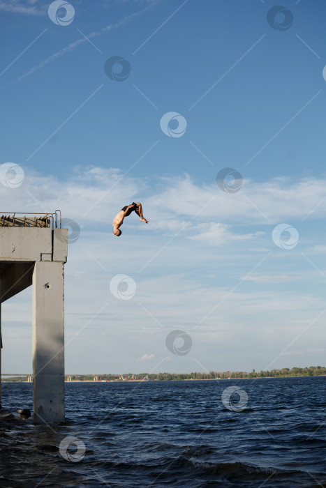 Скачать Мужчина прыгает в море с пирса фотосток Ozero