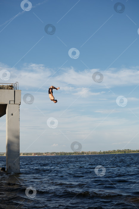 Скачать Мужчина прыгает в море с пирса фотосток Ozero