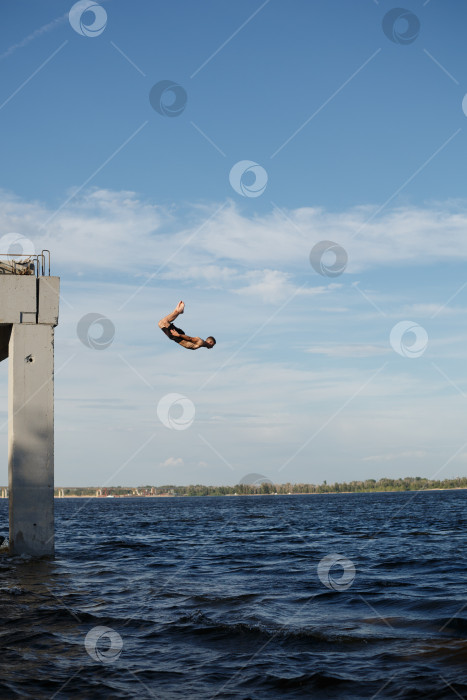 Скачать Мужчина прыгает в море с пирса фотосток Ozero