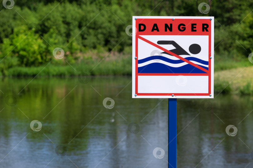 Скачать Знак для купания на берегу реки. Знак на берегу водохранилища: купание запрещено. Трава и летний день. Знак информирует вас о том, что здесь нельзя купаться фотосток Ozero