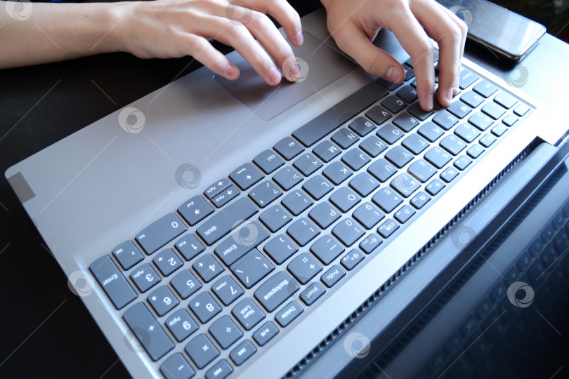 Скачать вид сверху на руки, печатающие на ноутбуке, человека, пишущего электронное письмо, работающего из дома, работающего в Интернете, копирайтера фотосток Ozero