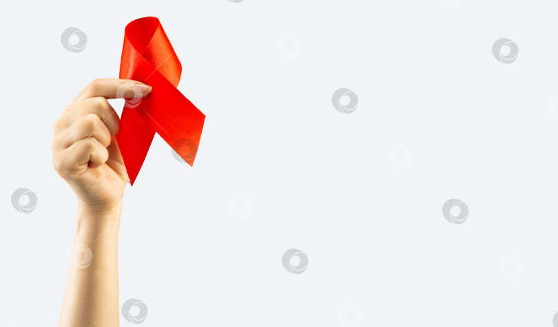 Скачать Концепция здравоохранения и медицины. Осведомленность о СПИДе. Женская рука держит красную ленту для информирования о СПИДе на белом фоне. Международный день борьбы со СПИДом фотосток Ozero