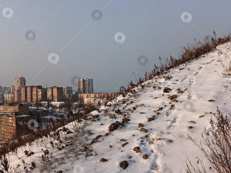 Скачать Снежный склон горы с городом на горизонте фотосток Ozero