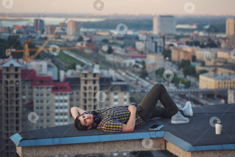 Скачать Мужчина слушает музыку на крыше. фотосток Ozero