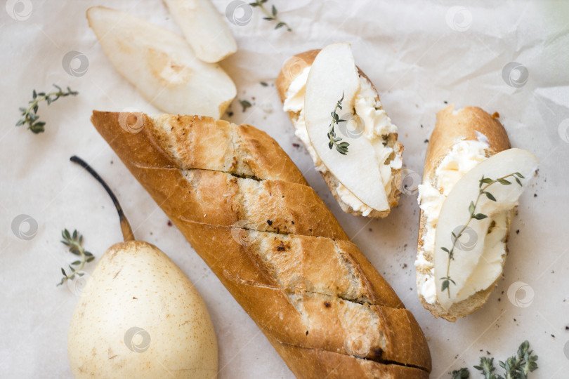 Скачать Багет хлеб с бутербродами сыр и груша на белом фоне фотосток Ozero