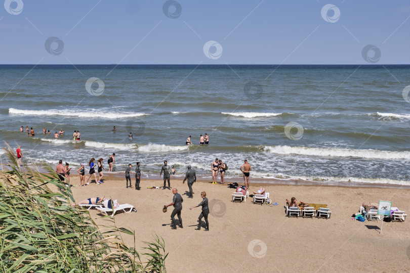 Скачать Сцена на пляже Азовского моря с людьми, наслаждающимися солнечными ваннами, купанием, грязелечением, Россия фотосток Ozero