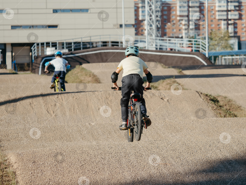 Скачать Два мальчика-гонщика на грунтовой гоночной трассе BMX фотосток Ozero