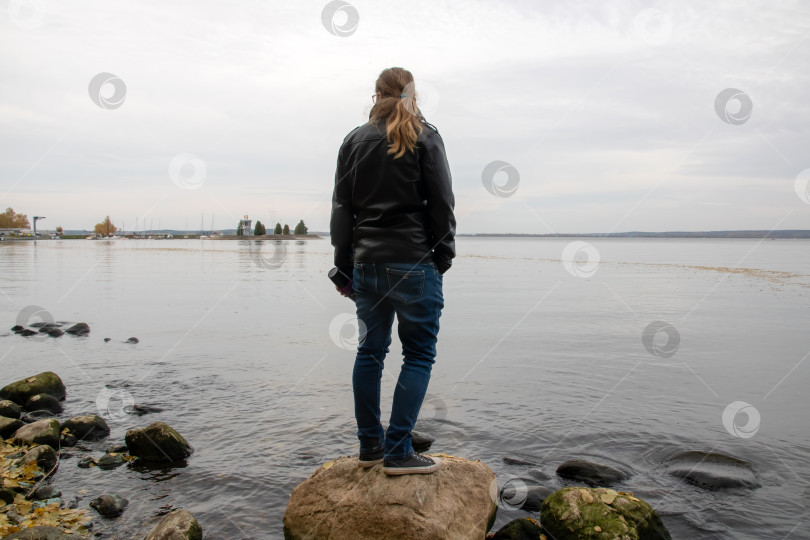 Скачать Женщина уверенно стоит на большом камне у кромки воды фотосток Ozero