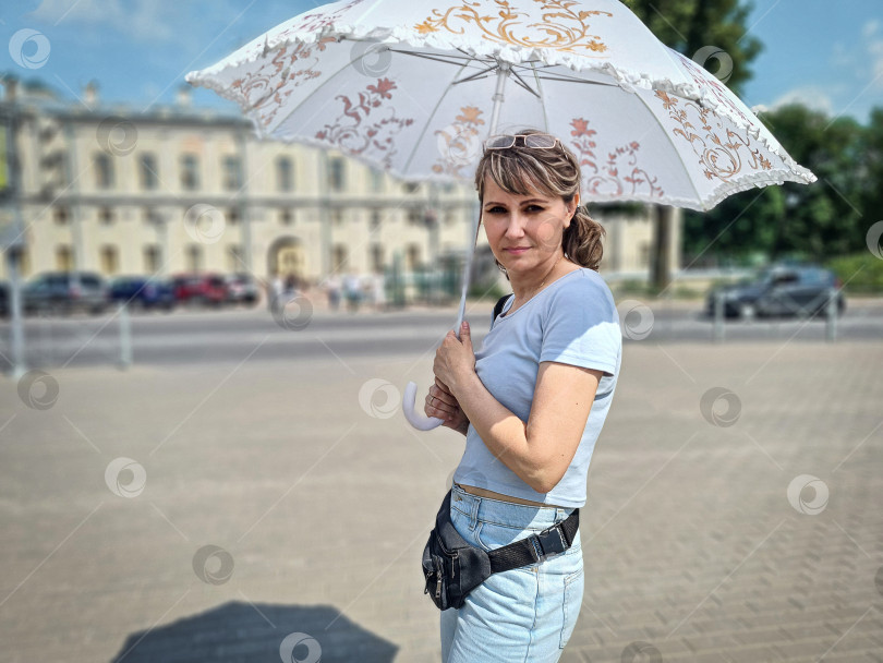 Скачать Девушка-туристка в летнем городе на прогулке с зонтиком от солнца в жаркий летний день фотосток Ozero