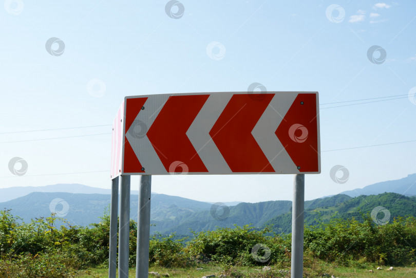Скачать Крупный план дорожного знака с несколькими поворотами на извилистой горной дороге фотосток Ozero