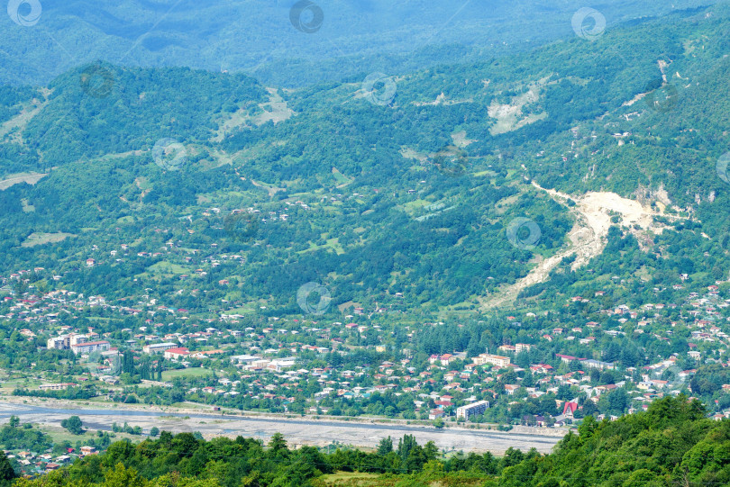 Скачать Грузинский горный пейзаж с проселочной дорогой, видом на деревню на берегу горной реки фотосток Ozero