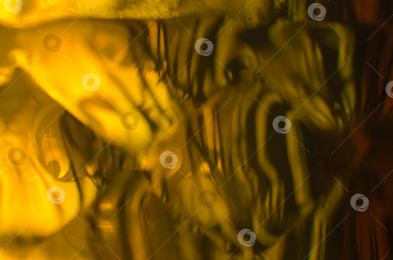Скачать Оранжево-желтый абстрактный фон. Элемент пластиковой бутылки с янтарной жидкостью в солнечный день. фотосток Ozero
