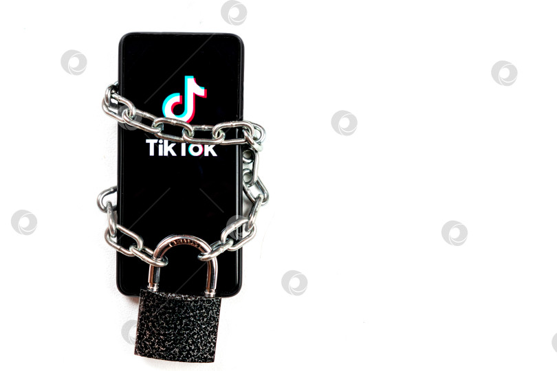 Скачать Логотип Tiktok на смартфоне. Телефон привязан железной цепью и имеет большой висячий замок. Свобода бизнеса и свобода слова. Дональд Трамп запретил Tiktok в Соединенных Штатах. Россия, Казань - 08 августа 2020 года. фотосток Ozero