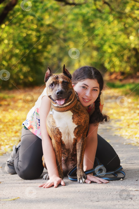 Скачать Счастливая молодая женщина со своим псом питбулем фотосток Ozero