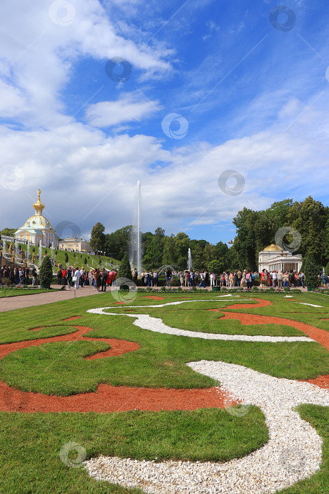 Скачать Россия, Санкт-Петербург, Петергоф, 4 июля 2018 года. На фото фонтан "Большой каскад" в Верхнем парке Государственного музея-заповедника "Петергоф" и люди, прогуливающиеся по парку фотосток Ozero