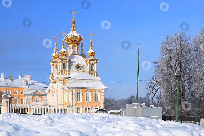 Скачать Россия, Санкт-Петербург, Петергоф, 21 февраля 2018 года. На фотографии изображена главная придворная церковь в Верхнем парке Государственного музея-заповедника "Петергоф" и люди, прогуливающиеся по парку и любующиеся архитектурой. фотосток Ozero