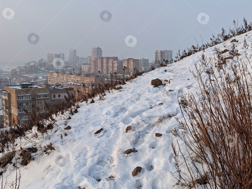 Скачать Заснеженная гора на фоне городских домов фотосток Ozero