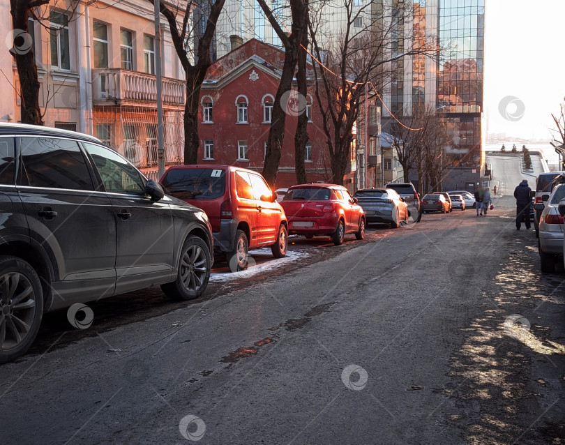 Скачать Городская улица с припаркованными машинами в свете заката фотосток Ozero