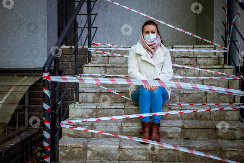 Скачать Фотография девушки в маске. Сидел на улице с лентами, предупреждающими об опасности. фотосток Ozero