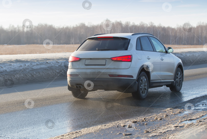 Скачать Автомобиль движется по мокрой проселочной дороге. фотосток Ozero