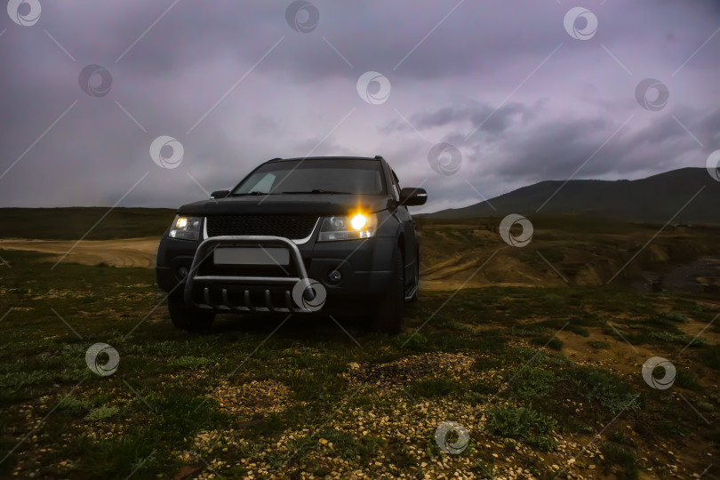 Скачать Внедорожник на поле под пасмурным небом. фотосток Ozero