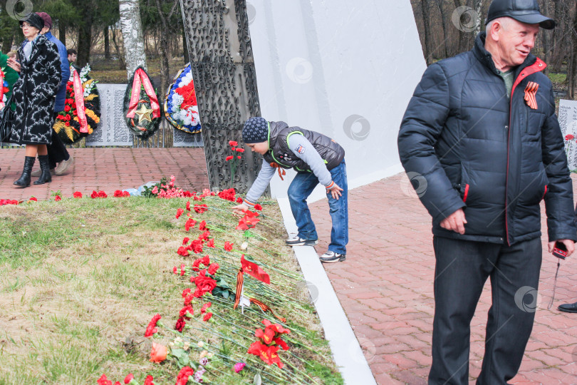 Скачать Подросток кладет цветы на могилу. фотосток Ozero