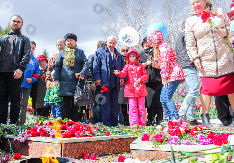 Скачать Люди и цветы вокруг Вечного огня. фотосток Ozero