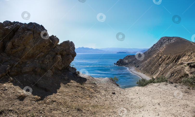 Скачать лагуна у моря, освещенная солнцем в горах фотосток Ozero
