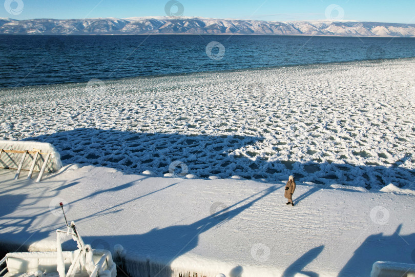 Скачать Замерзший пирс, льдины и снег у берега, вода в озере Байкал фотосток Ozero