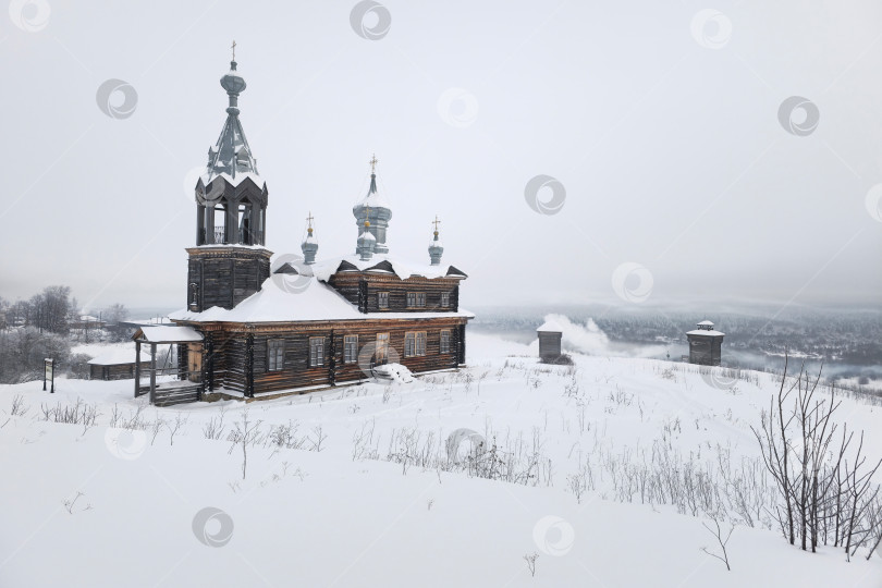 Скачать Заснеженный холм со старой деревянной церковью в Чердыни. фотосток Ozero