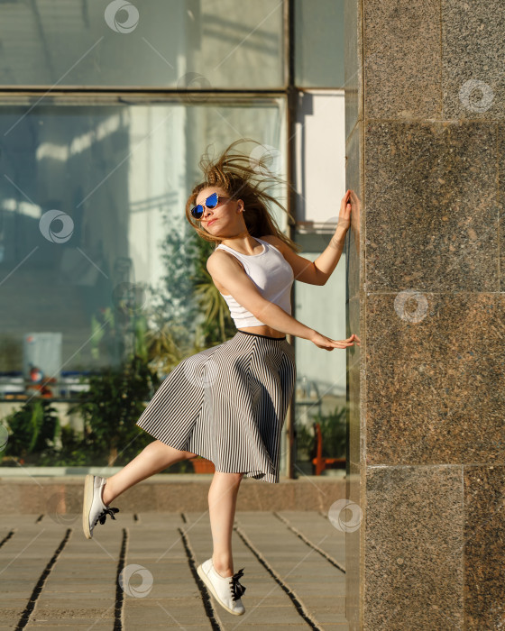 Скачать Девушка танцует рядом с торговым центром фотосток Ozero