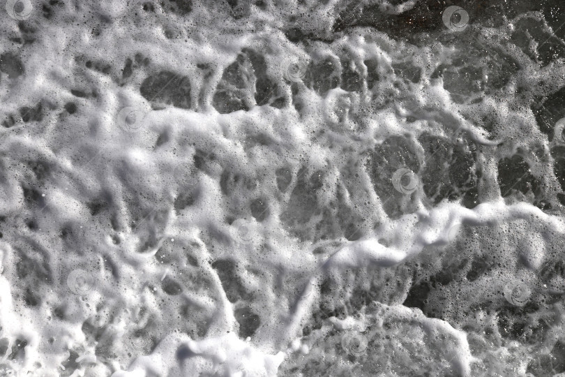 Скачать Фон с движущейся поверхностью морской воды. Текстура пены морской волны. Фон с водоворотами на открытом воздухе. фотосток Ozero