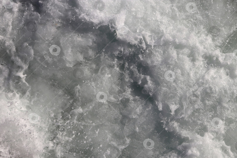 Скачать Белый фон с движущейся поверхностью морской воды. Текстура пены морской волны. Фон с водоворотами на открытом воздухе. фотосток Ozero