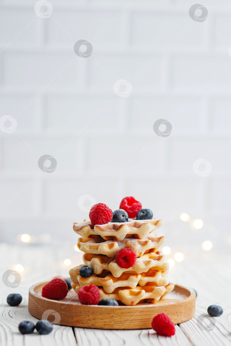 Скачать Венские вафли с ягодами на белом деревянном фоне. фотосток Ozero