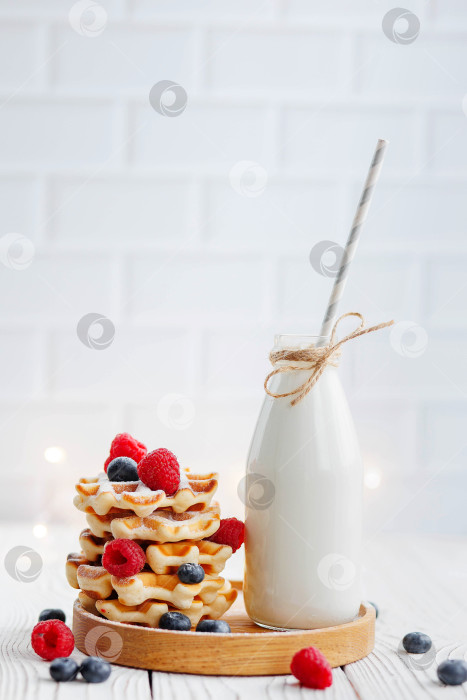 Скачать Венские вафли с черникой и малиной на белом фоне. Бутылка молока и венские вафли. фотосток Ozero