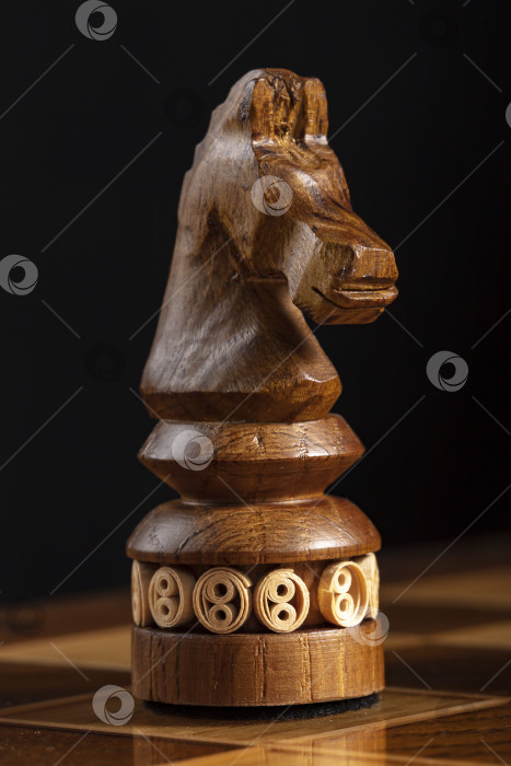 Скачать Шахматная деревянная фигурка черного коня. Игра-головоломка с хитрыми комбинациями, требующая планирования и обдумывания. фотосток Ozero