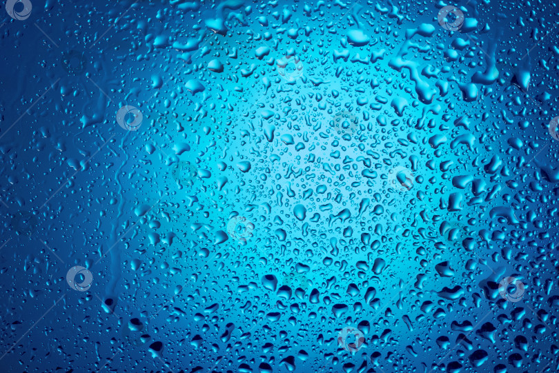 Скачать Капли воды на стекле на синем фоне. фотосток Ozero