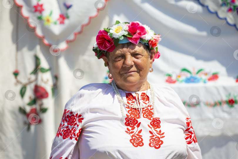 Скачать Пожилая белоруска или украинка в национальной одежде на фоне полотенец. Бабушка по национальности славянка. фотосток Ozero