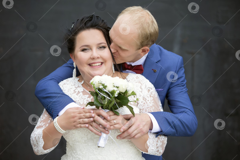 Скачать Жених целует красивую и счастливую толстую невесту. фотосток Ozero
