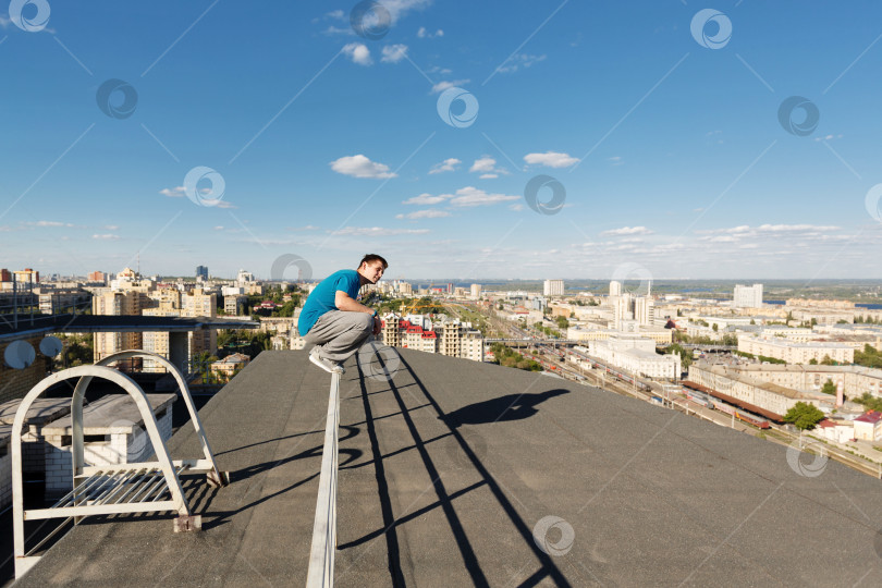 Скачать Кровельщик сидит на перилах фотосток Ozero