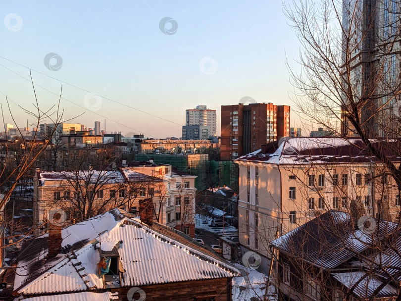 Скачать Городские здания в снегу на фоне закатного неба фотосток Ozero