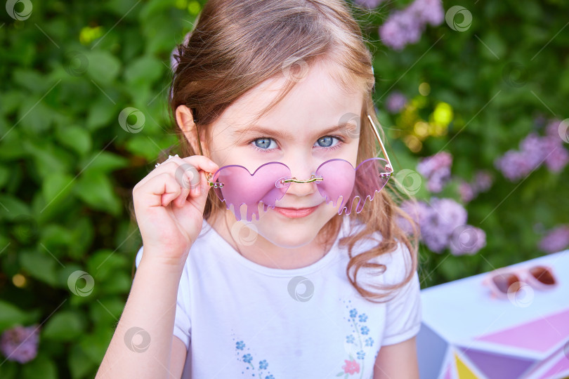 Скачать Милая улыбающаяся девочка 3-5 лет с длинными волосами позирует на открытом воздухе на фоне природы. Смотрит в камеру. Весенний сезон. Детство фотосток Ozero