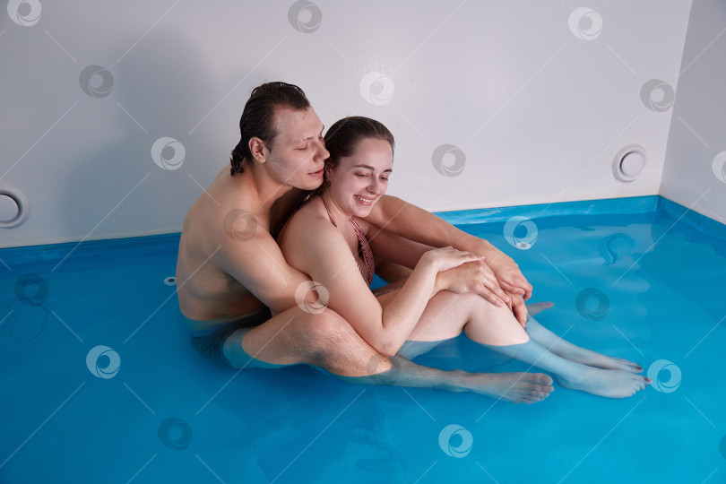 Скачать Парень и девушка рядом друг с другом в бассейне, в воде с морской солью. Плавающий концепт. фотосток Ozero